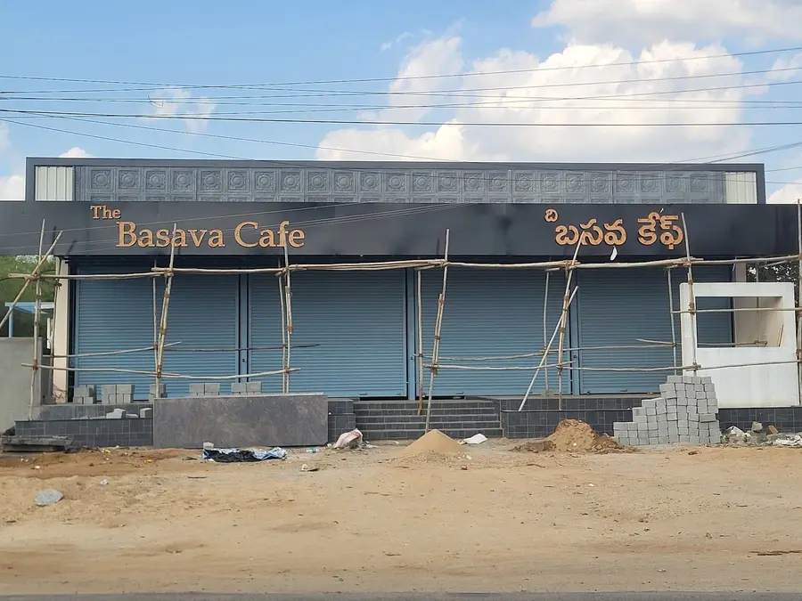 The building under construction, bamboo scaffolding against the front and the sign already in place.